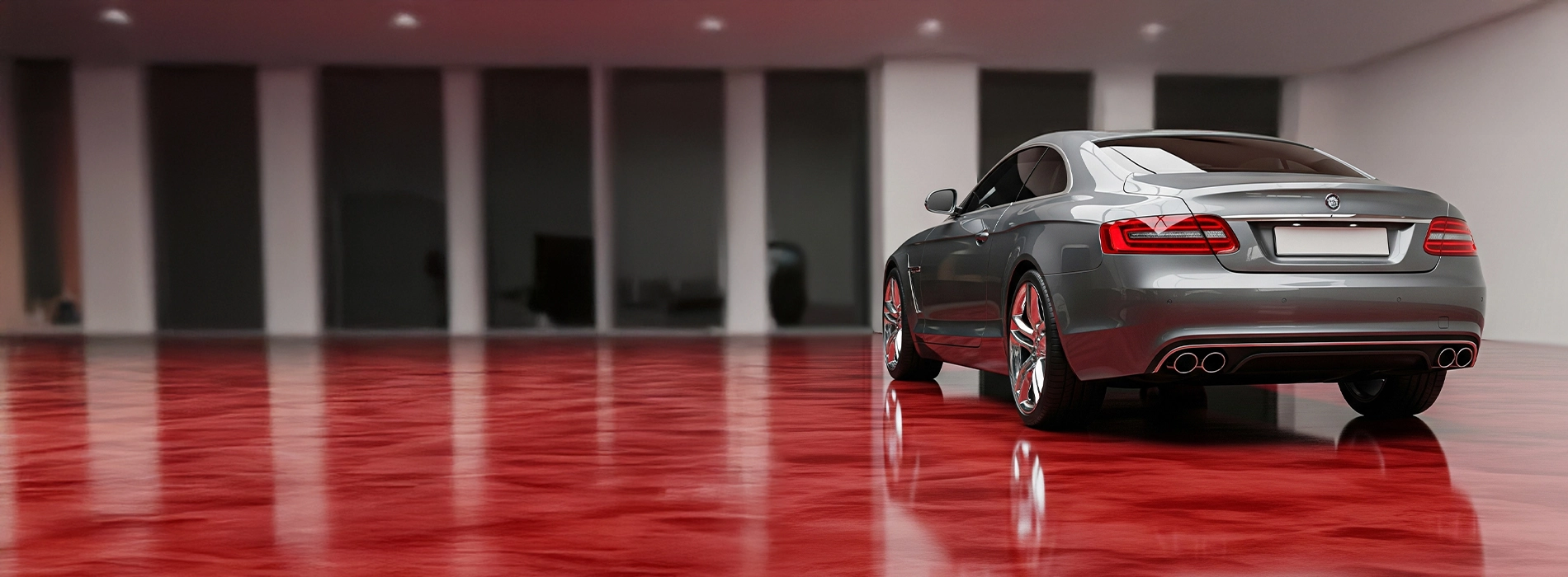 Luxury grey car parked on metallic red epoxy garage floor with high-gloss finish.